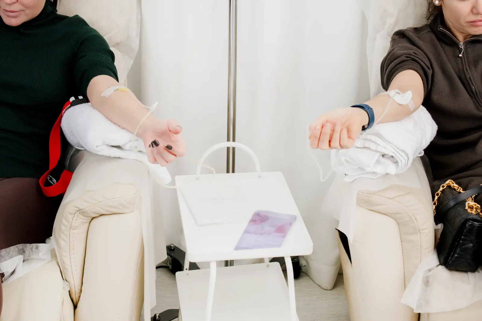 Two clients receiving IV vitamin drips in recliners at a Westchester County infusion clinic