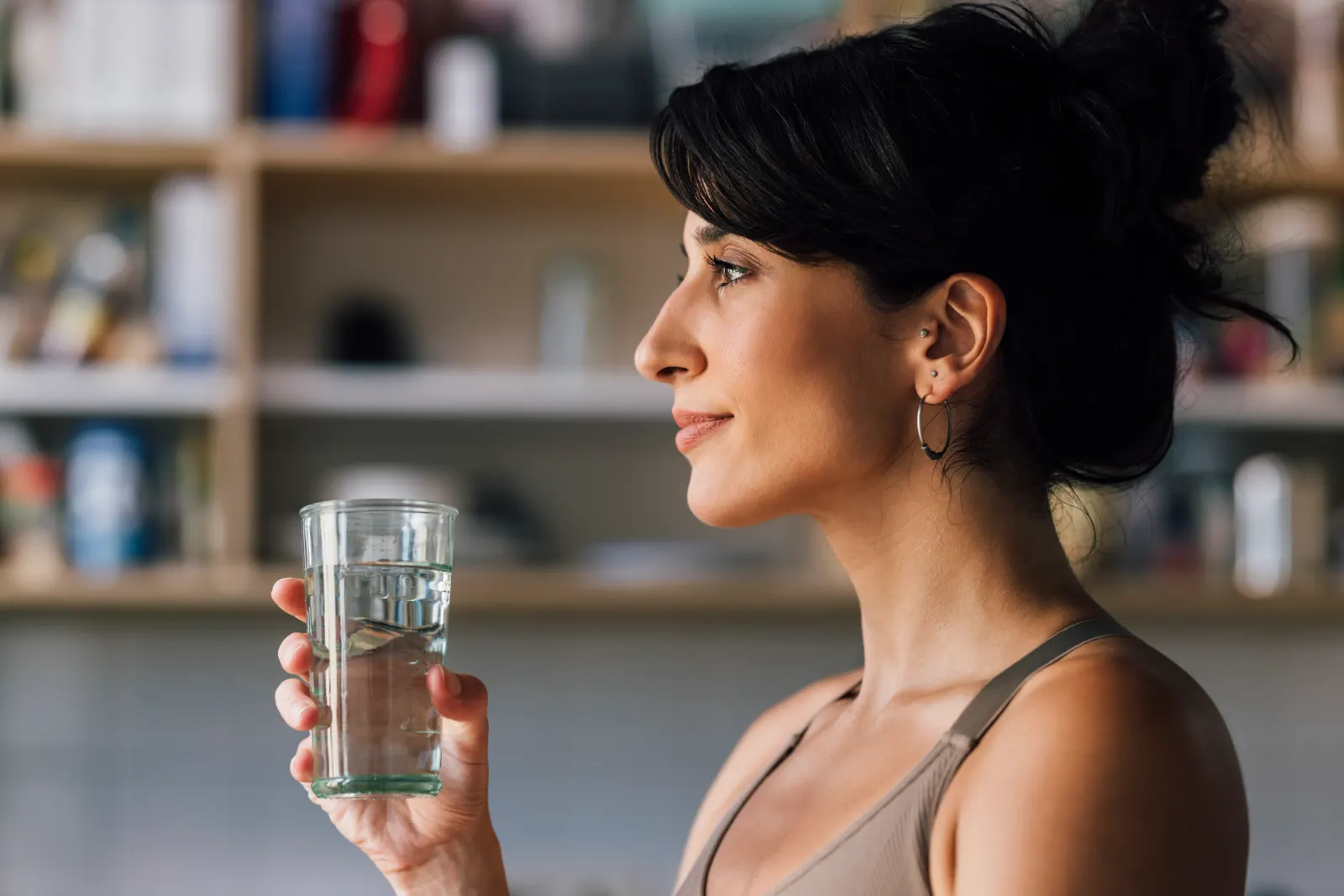 Woman drinking a glass of water in profile, supporting hydration and rehydration at a Westchester County clinic