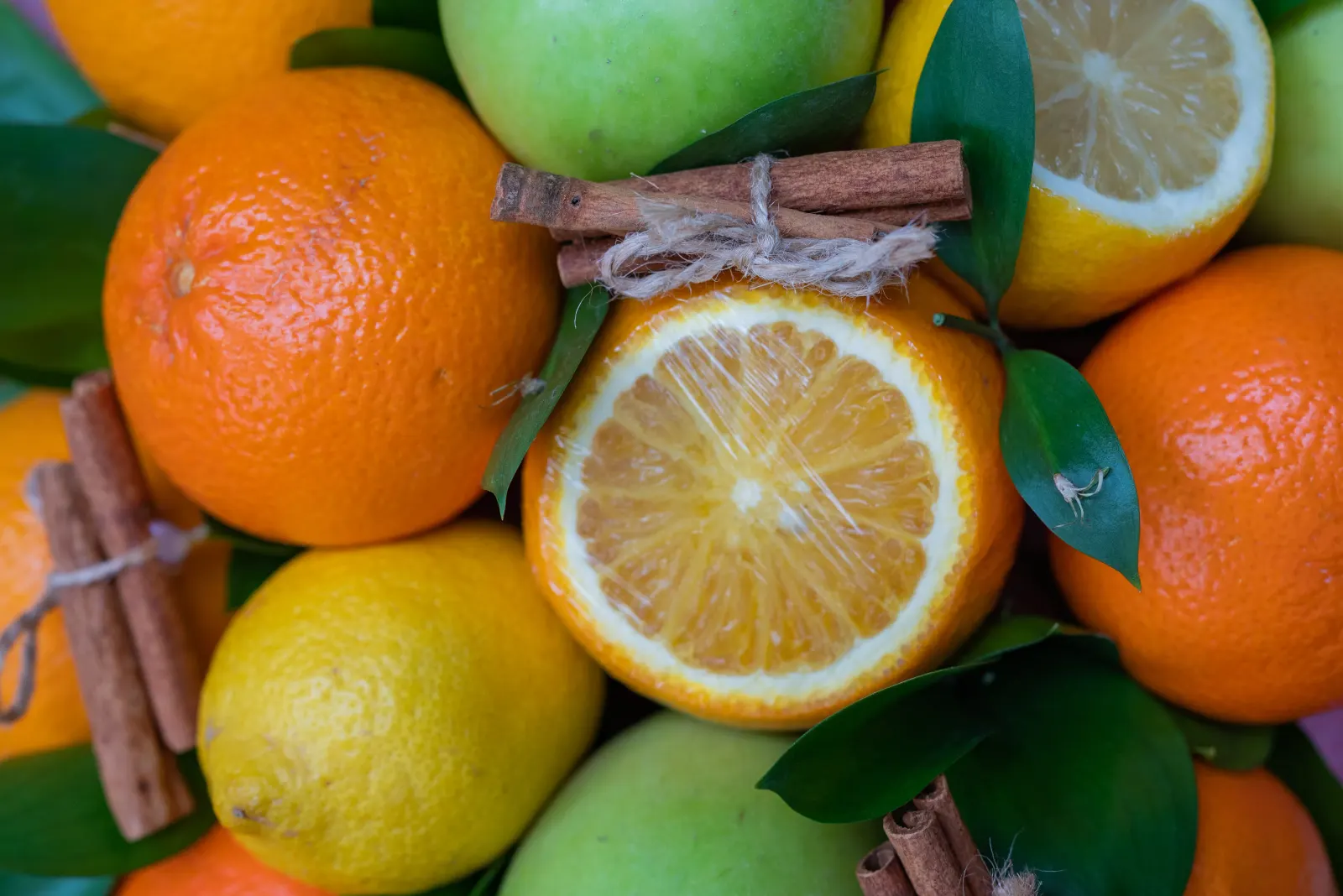 Fresh oranges, lemons and apples with cinnamon sticks, vitamin C citrus for immune support