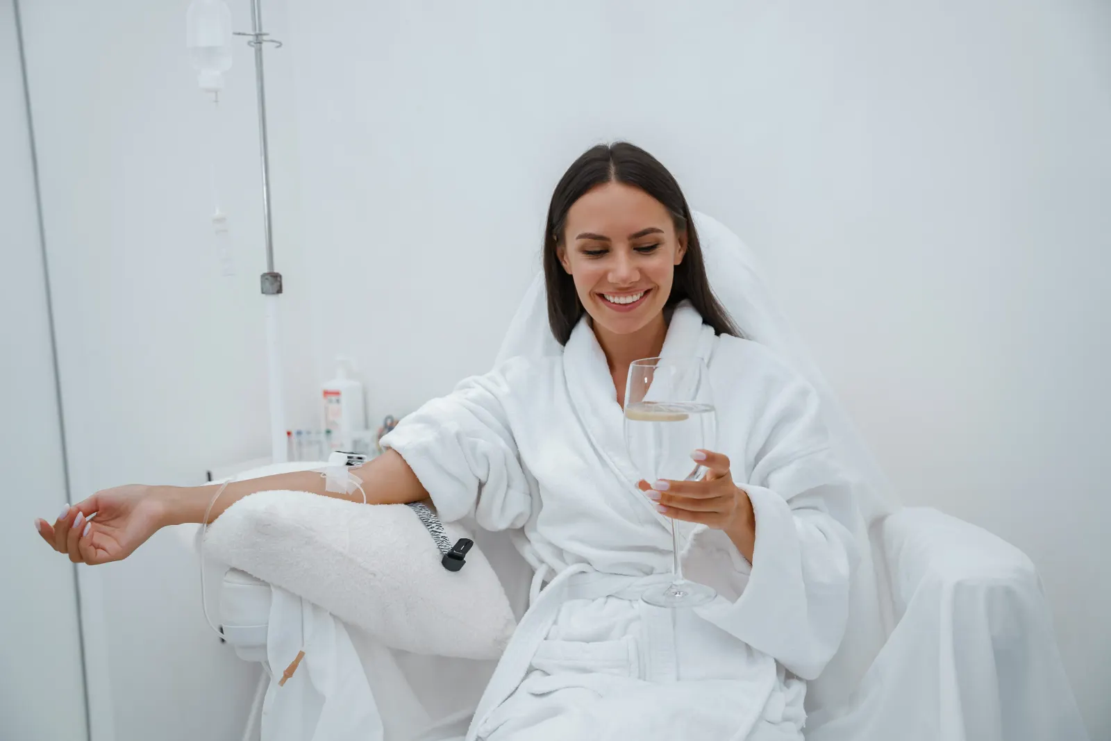 Woman in a white robe smiling during a Myers IV therapy drip session at a New Rochelle clinic